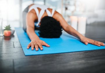 woman in child's pose on a yoga mat