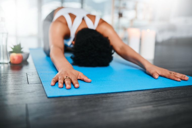 woman in child's pose on a yoga mat