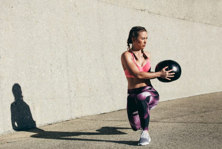 woman doing a workout with a medicine ball
