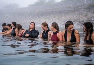 a group of women getting prepared for a cold water swim
