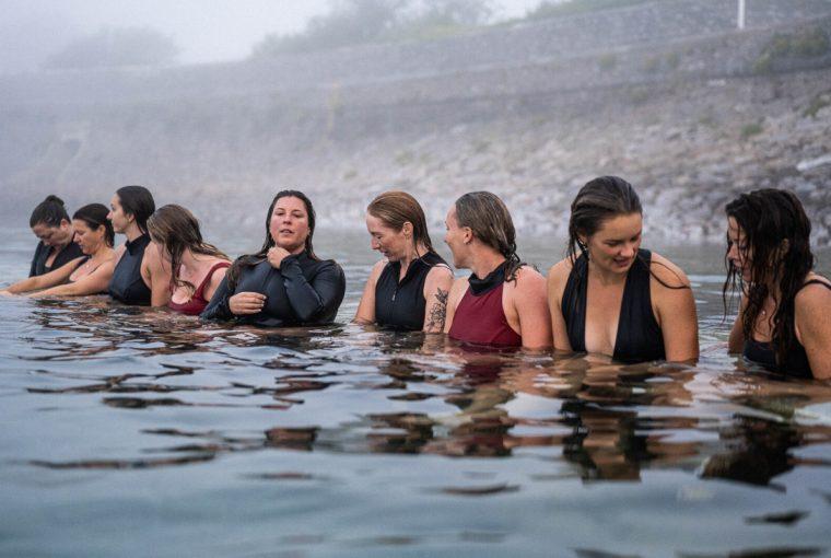 a group of women getting prepared for a cold water swim