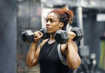 a woman using dumbbells for shoulder press workout