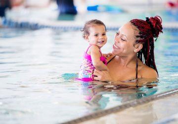 a mother and her daughter enjoying a swim in the pool